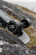 A close-up of a skateboard deck with SaltRide logo resting on a sunlit Salt Lake City street.