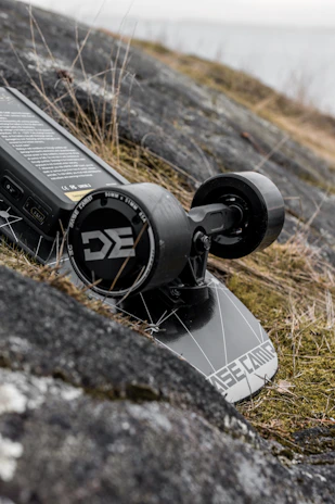 A close-up of a skateboard deck with SaltRide logo resting on a sunlit Salt Lake City street.