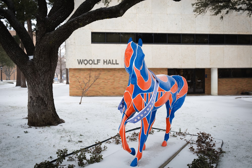 a colorful horse statue in front of a building