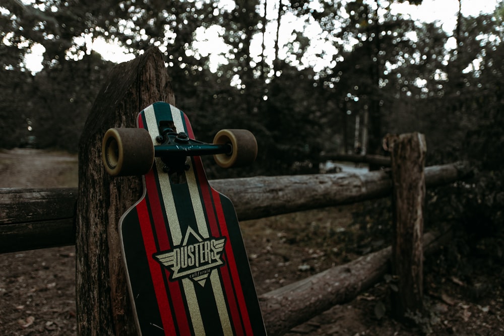 a skateboard leaning against a wooden fence