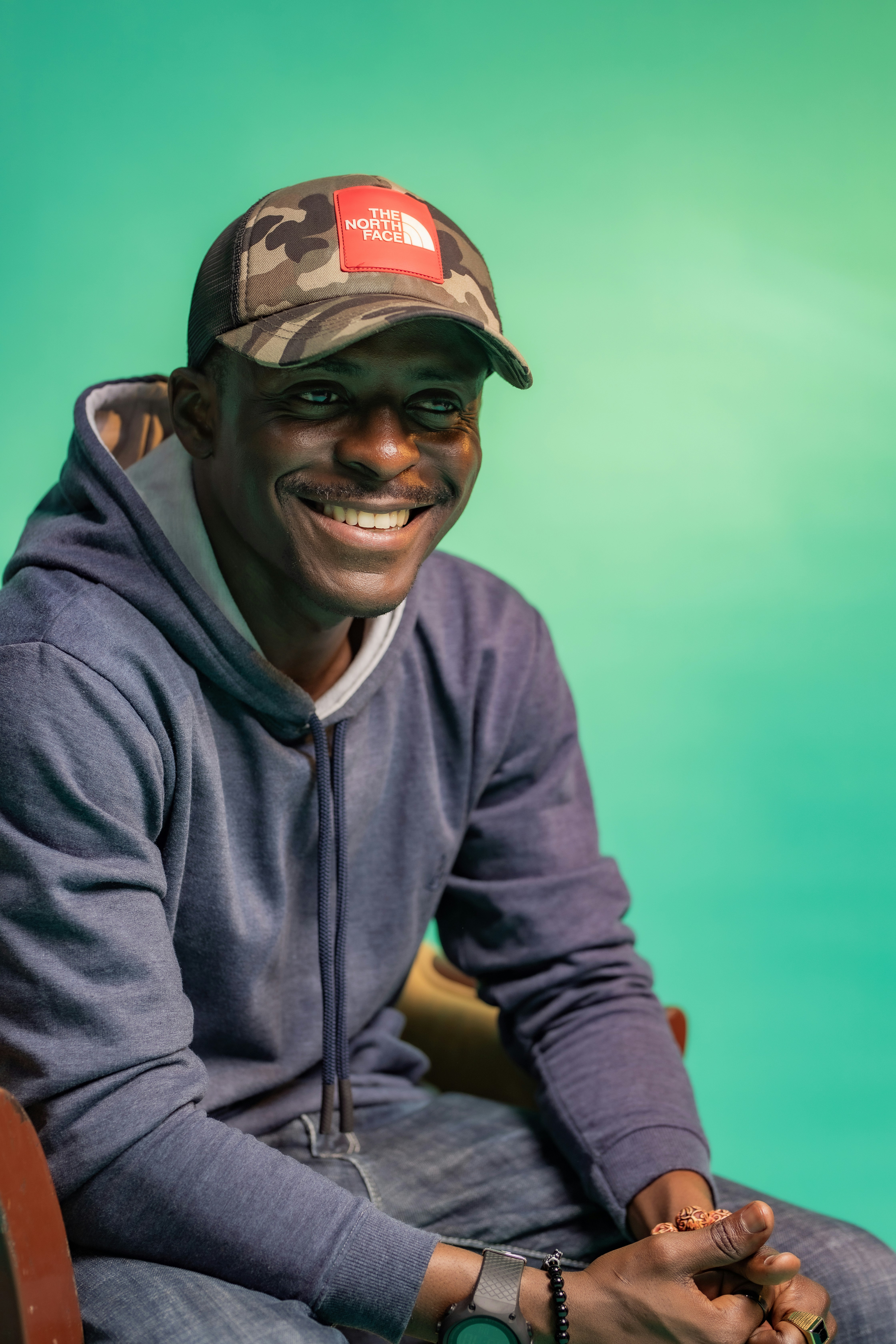a man sitting in a chair wearing a hat