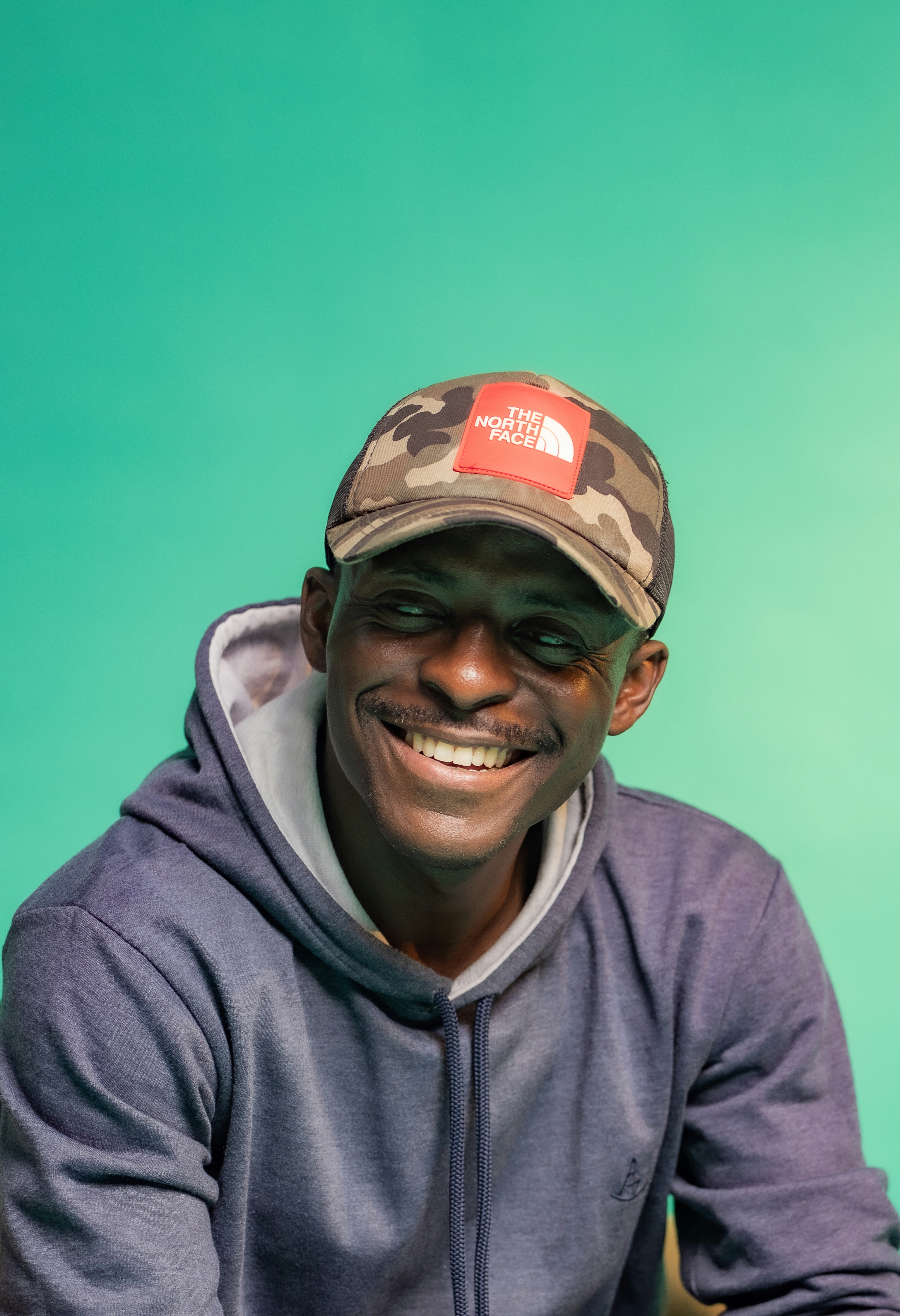 a man wearing a hat and smiling for the camera