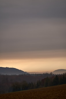 A calm Wyoming landscape at dusk with charcoal-colored mountains in the background.