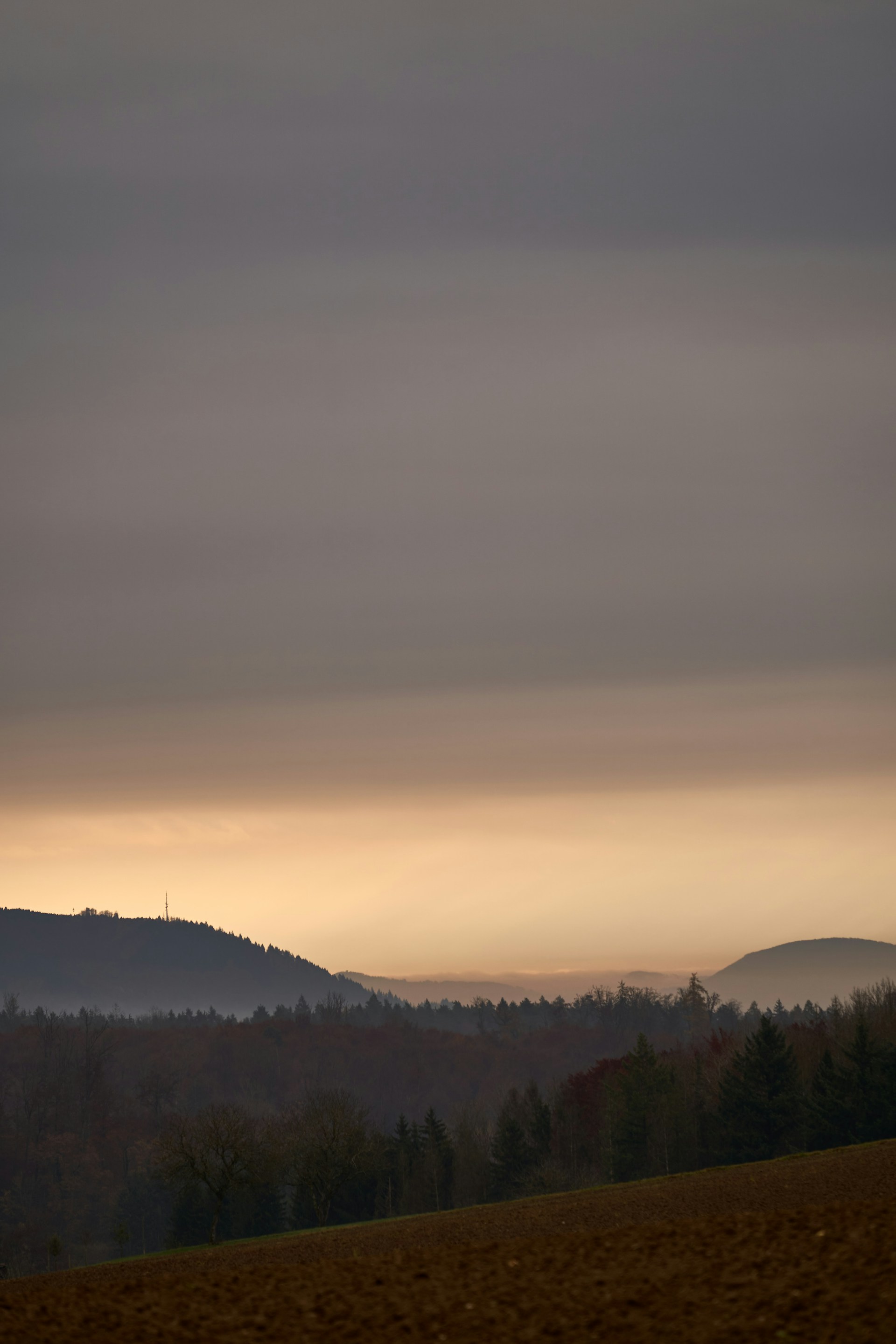 A quiet landscape at dusk, where shadows blend with fading light to evoke calm and reflection.