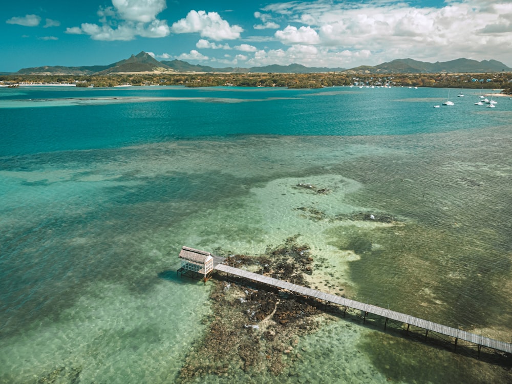 an aerial view of a pier in the middle of the ocean