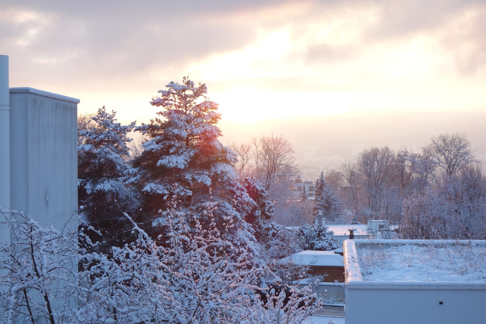 the sun is setting over a snowy city