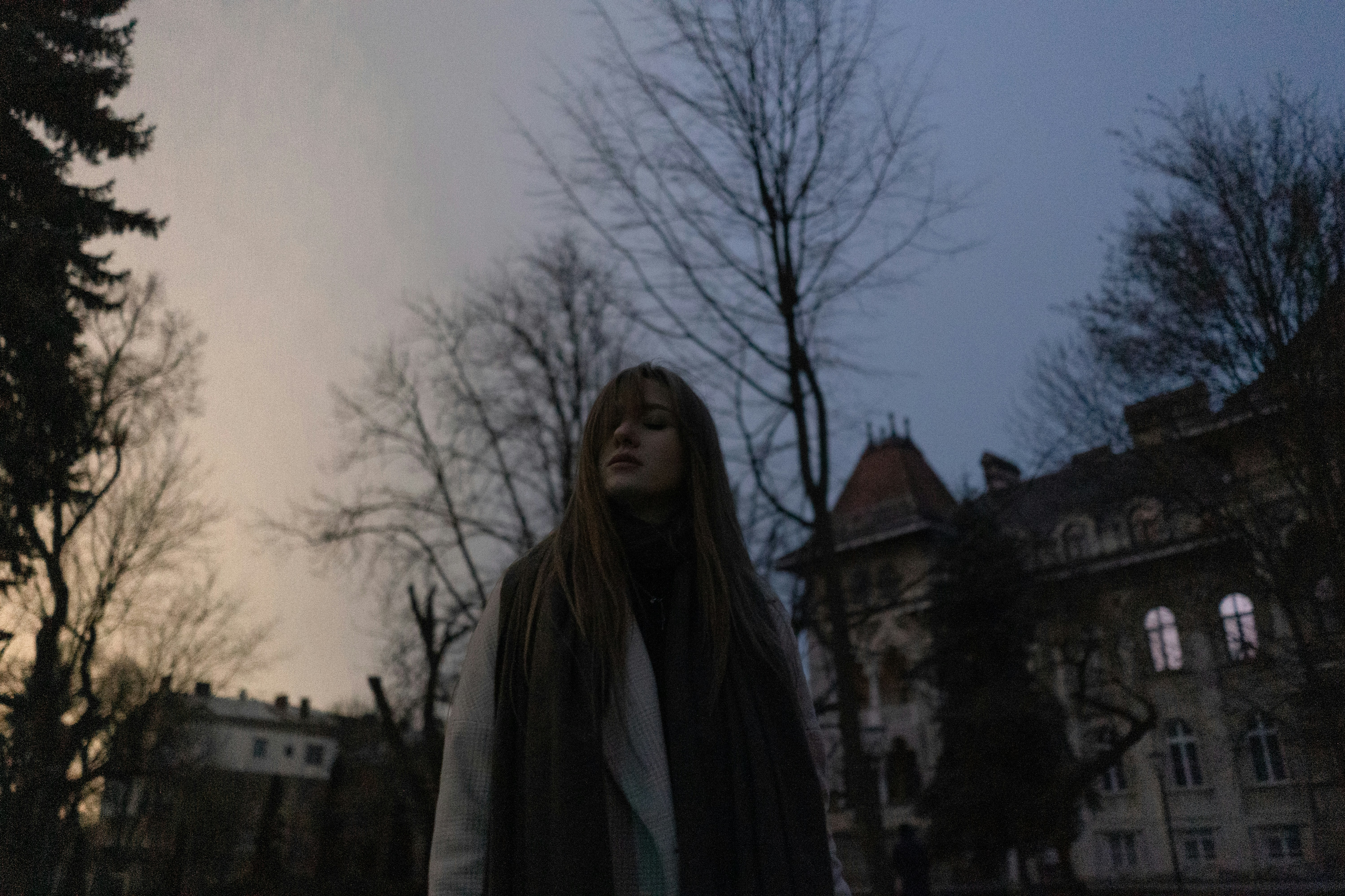a woman with long hair standing in front of a building