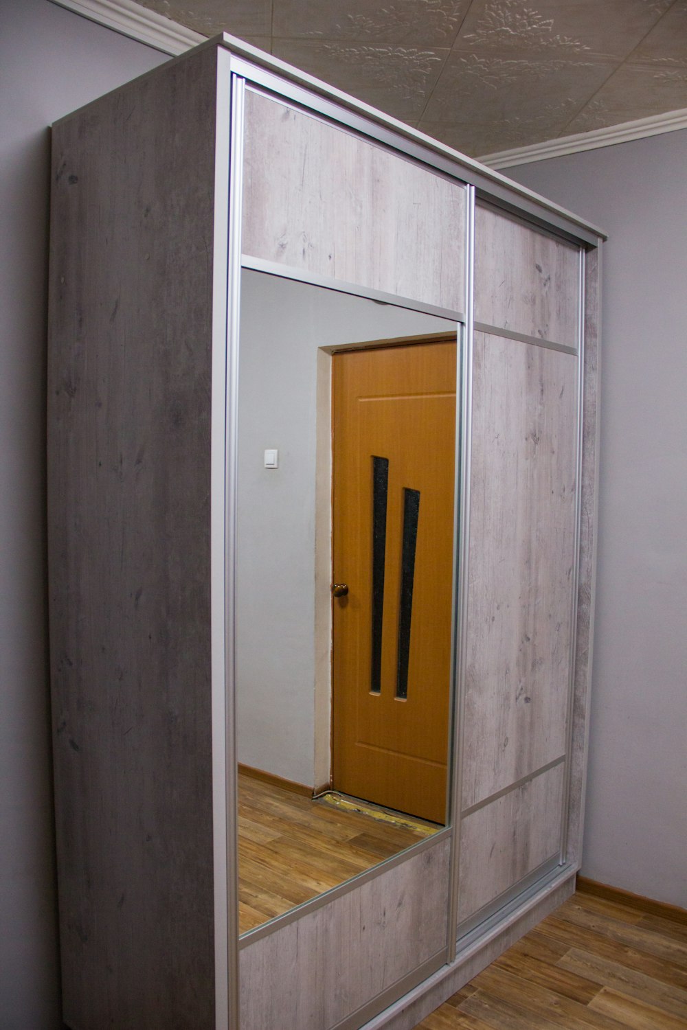 a mirror reflecting a door in a room