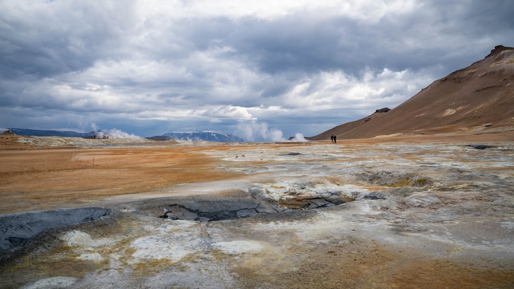 a person standing in a barren area with mountains in the background