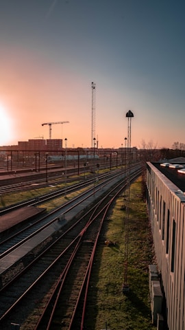 the sun is setting over a train yard