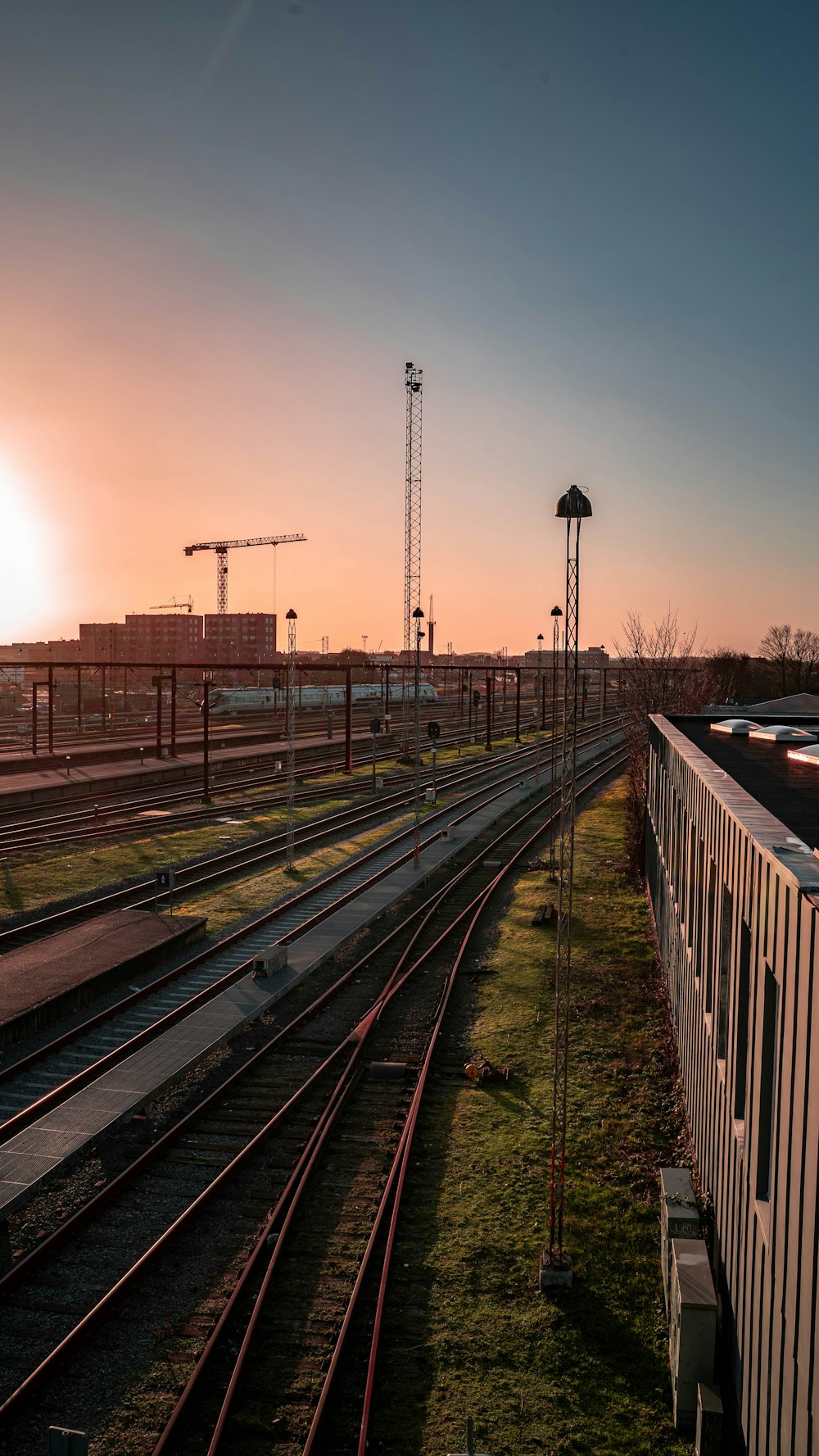 the sun is setting over a train yard
