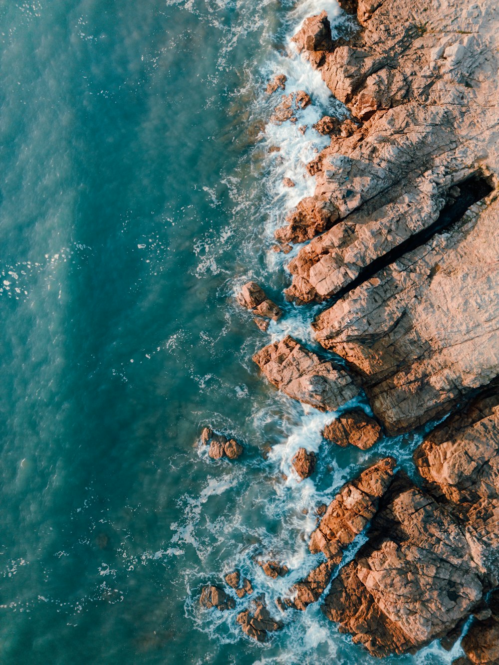 a bird's eye view of the ocean and rocks