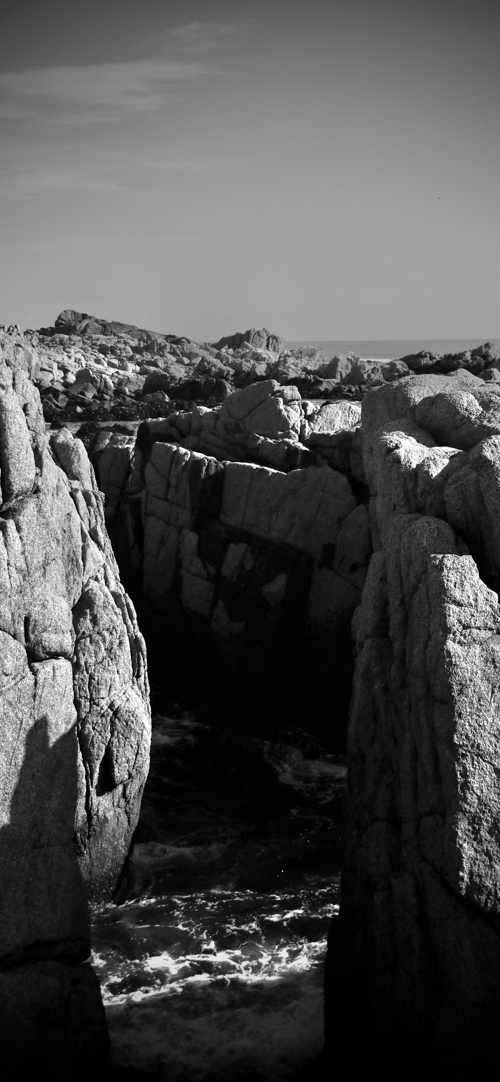 a black and white photo of rocks and water