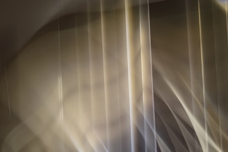 Abstract waves and grid patterns in soft gray and aqua blending into a light gradient background.