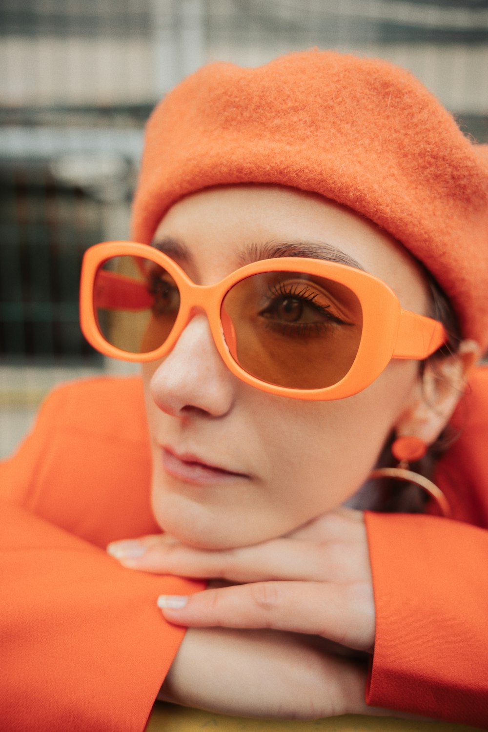 a woman wearing a bright orange hat and sunglasses