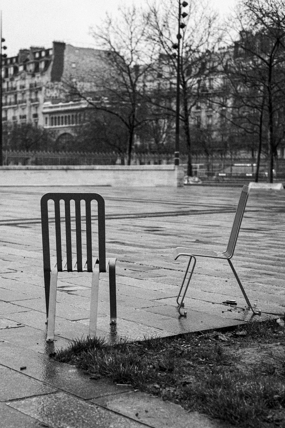 a couple of chairs sitting on top of a sidewalk