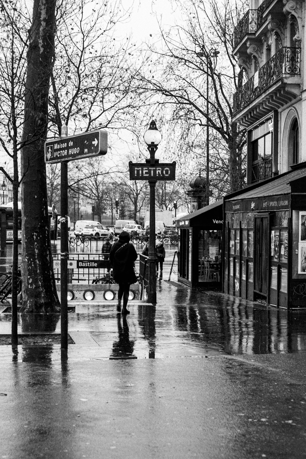 a black and white photo of people walking down a street