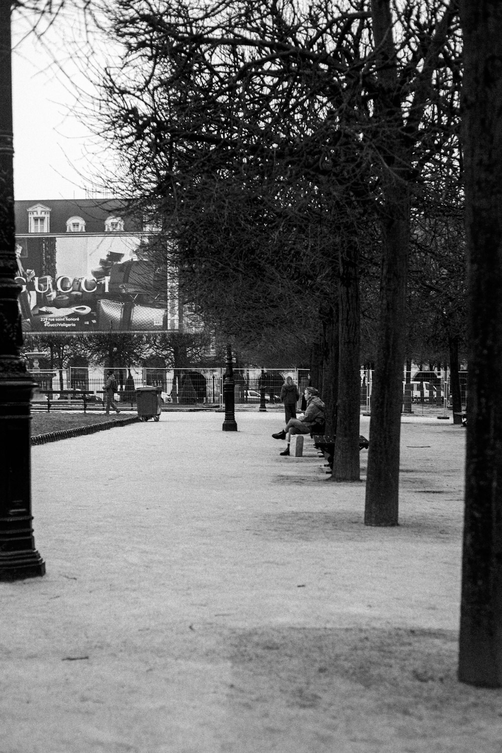 a black and white photo of people sitting on a bench