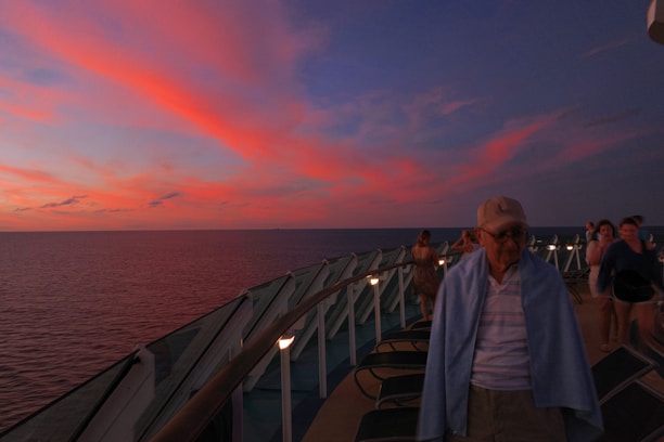 A happy couple enjoying a sunset on the deck of a luxury cruise ship.
