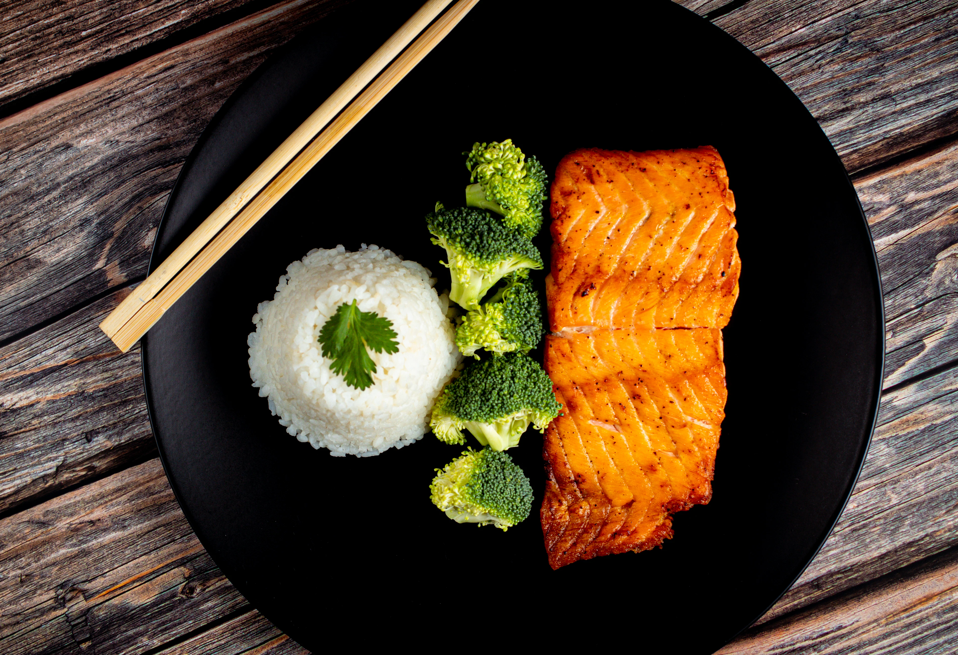 Pavé de saumon, riz blanc et brocoli sur une assiette noire