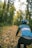 a man riding a bike down a leaf covered road