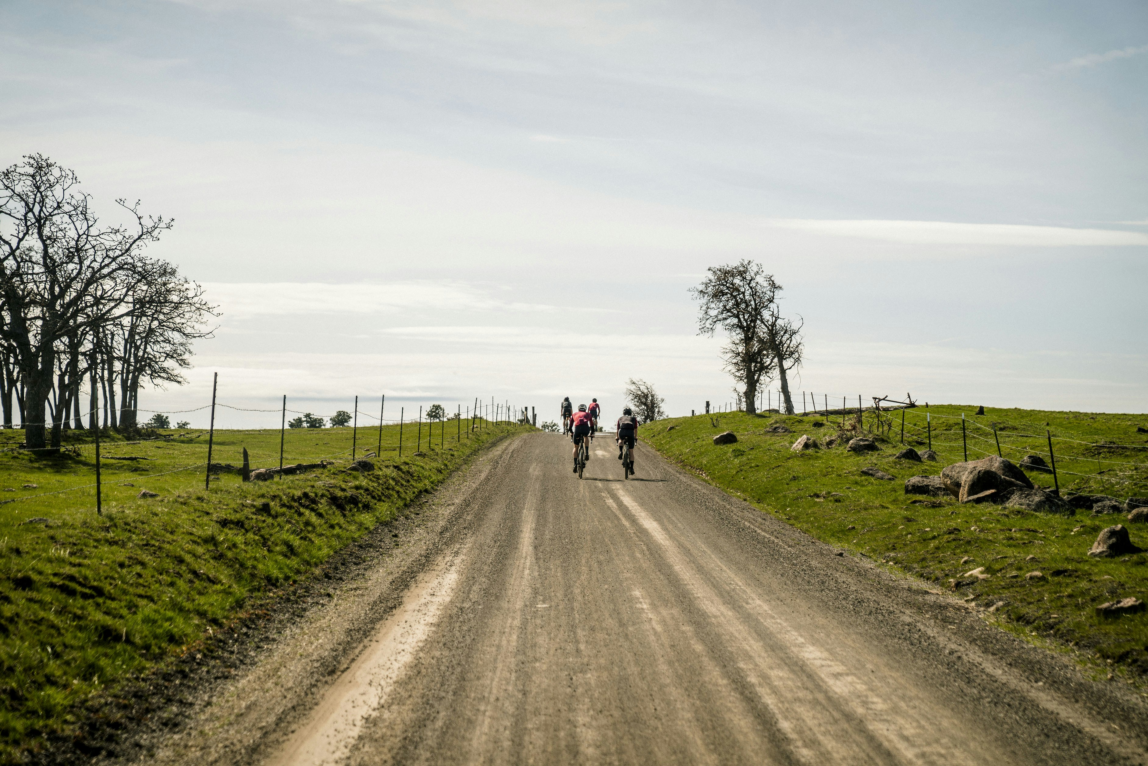 a group of people riding bikes down a dirt road