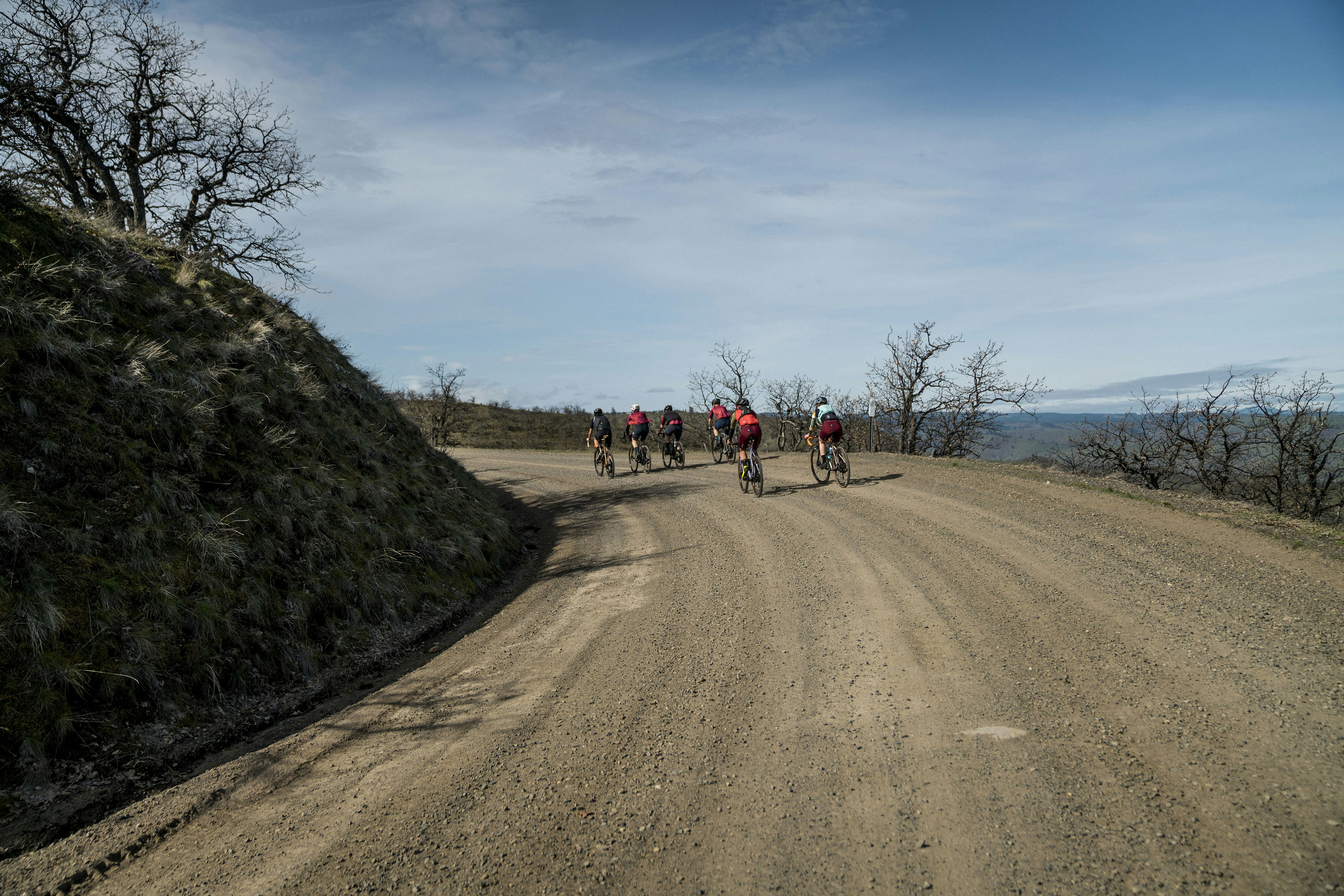 a group of people riding bikes down a dirt road