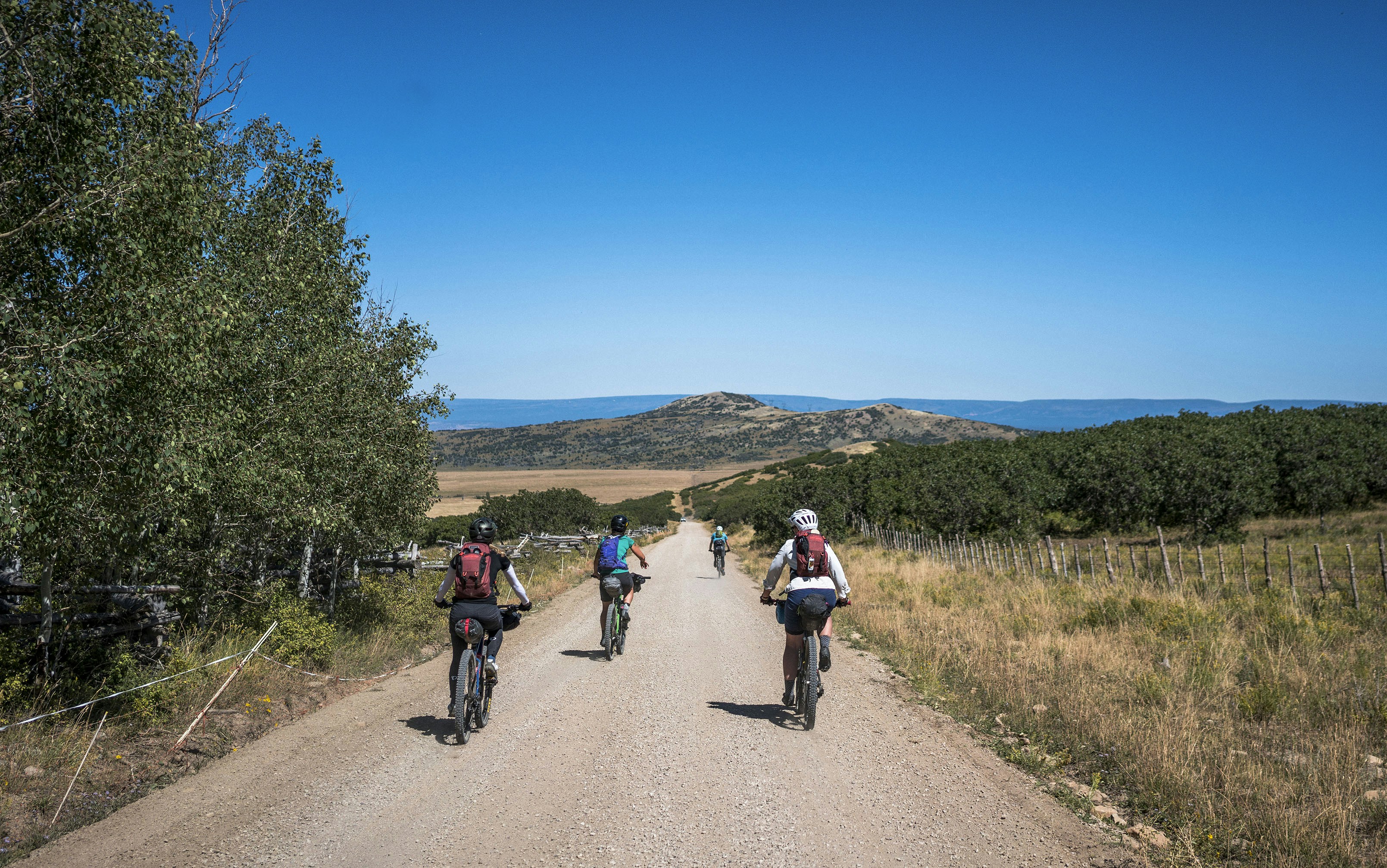 a group of people riding bikes down a dirt road