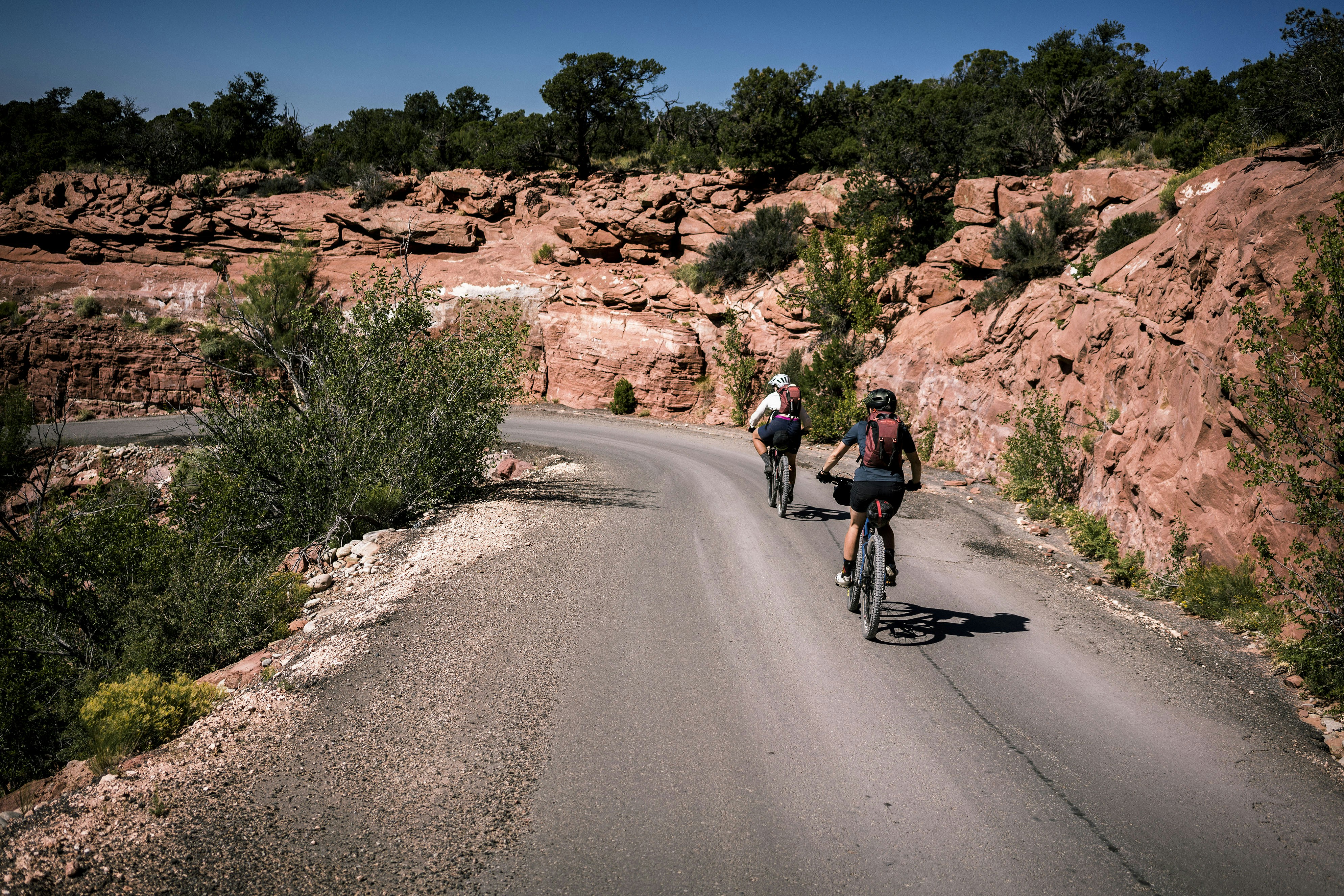 a couple of people riding bikes down a road