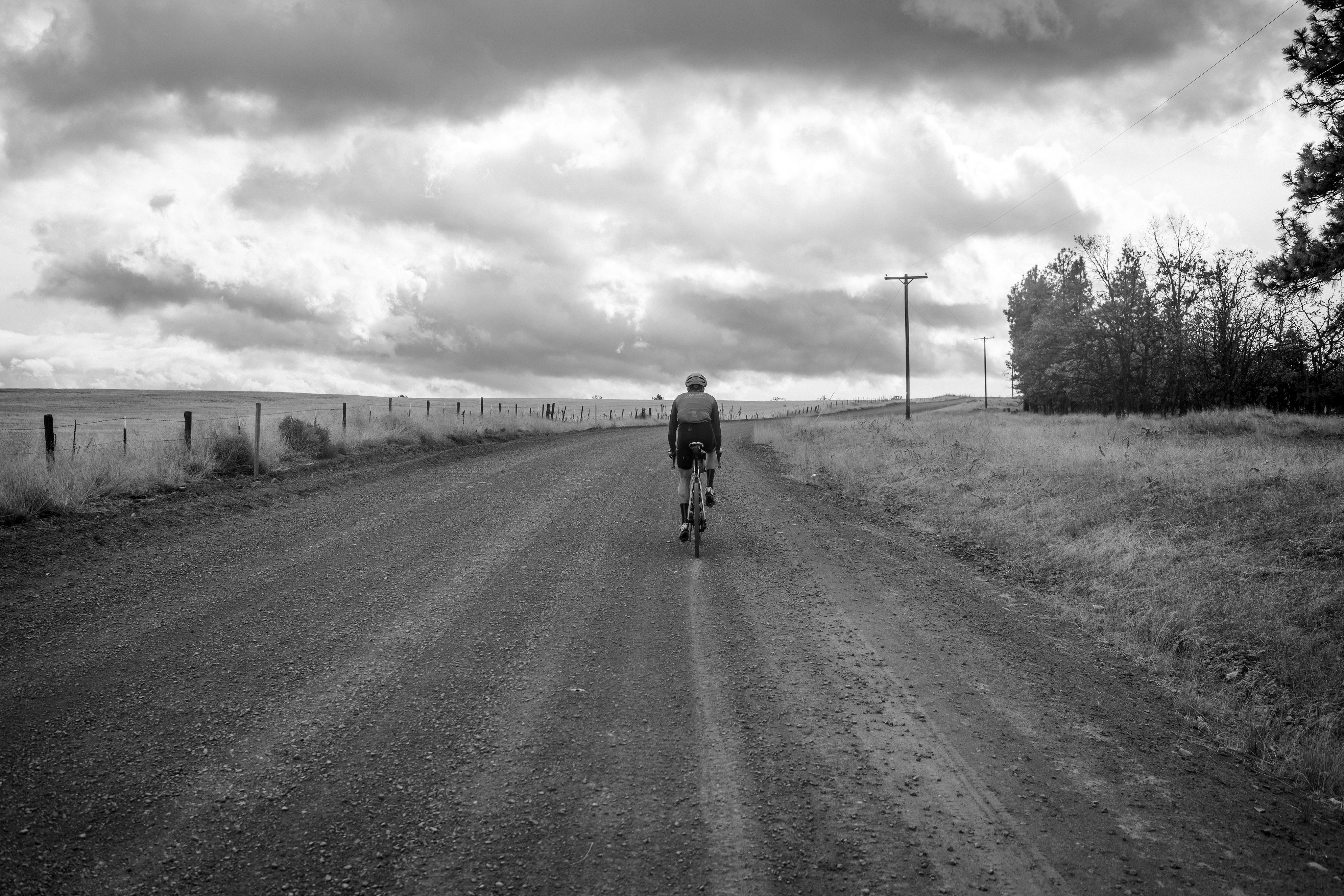 a man riding a bike down a dirt road