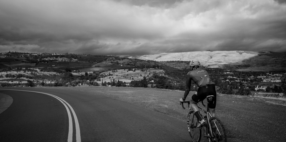 a man riding a bike down a curvy road