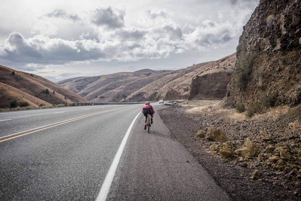 a person riding a bike down a road