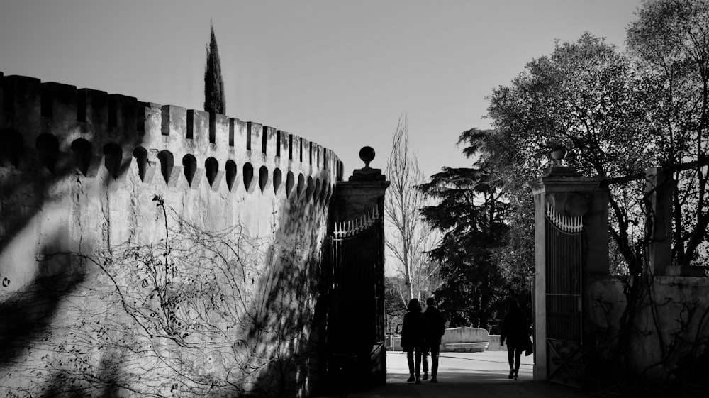a black and white photo of two people walking down a path