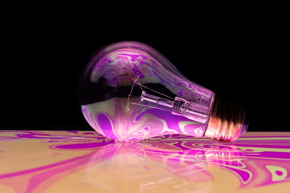 a purple light bulb sitting on top of a table