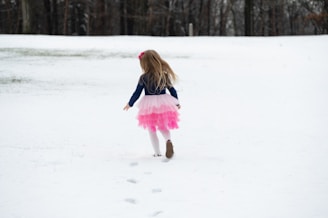 A young girl skiing on a snowy slope in France.