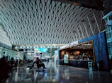 A panoramic shot of a group enjoying coffee at a cozy airport lounge, waiting for their flight.