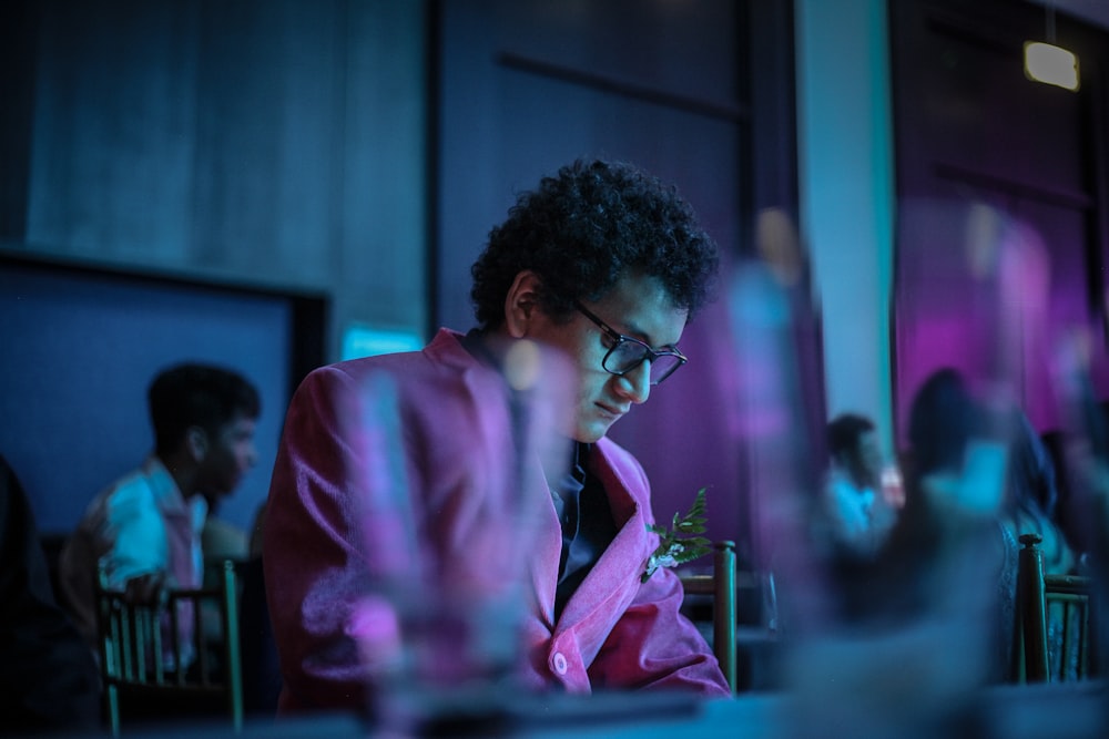a man in a pink jacket looking at his cell phone