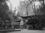 A serene scene of a person wearing a scented bracelet while enjoying tea in a traditional Chinese garden