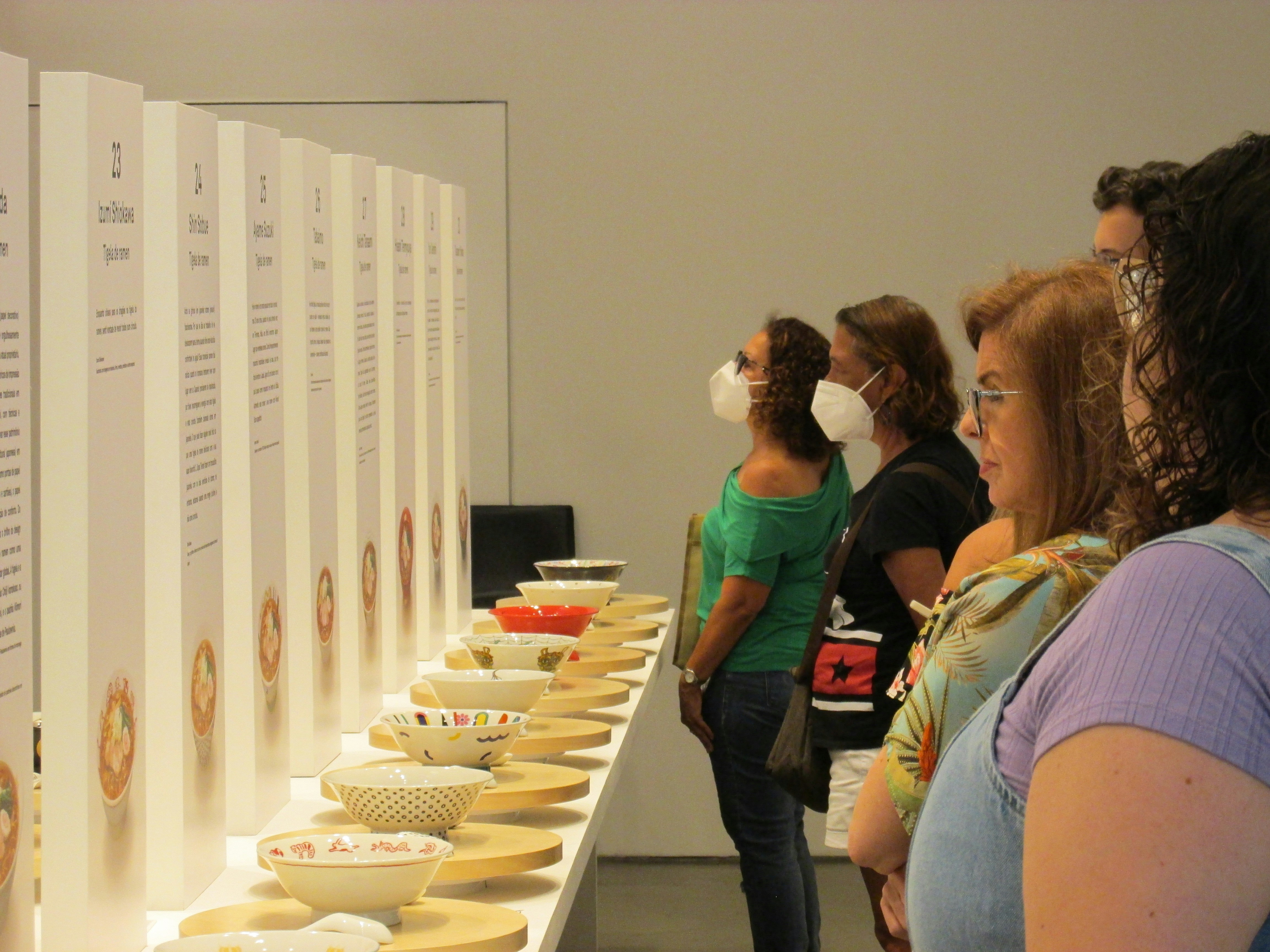 a group of people standing around a table with bowls on it