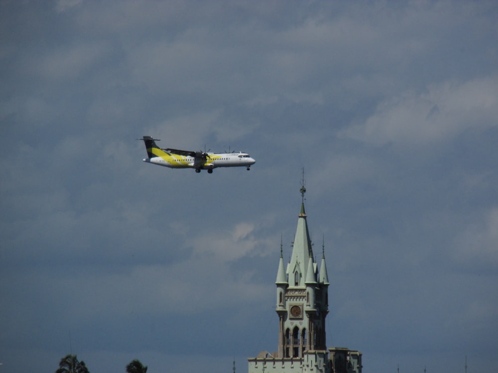 an airplane flying over a castle with a clock tower