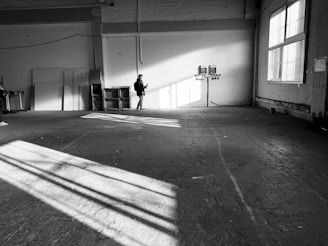 A team member vacuuming a large commercial space with natural light streaming in.