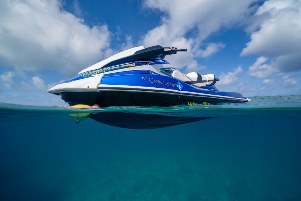 a blue and white boat floating in the ocean