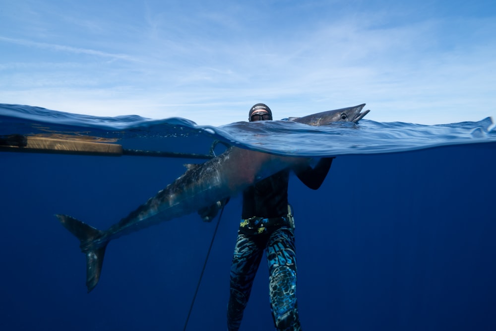 a man holding a large shark in the ocean