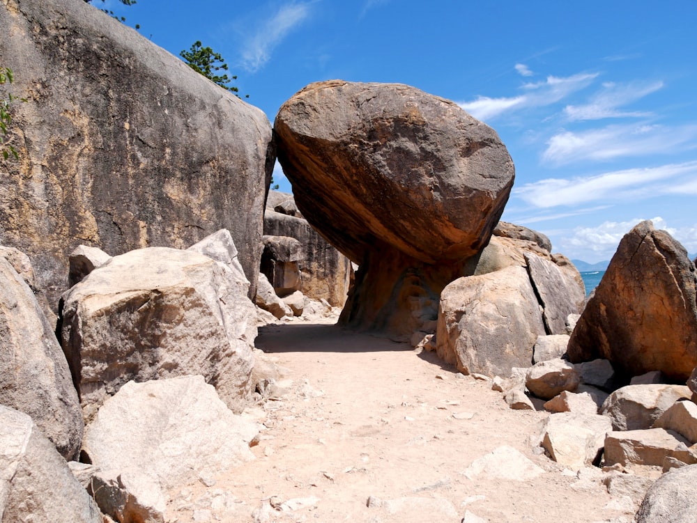 a large rock sitting on top of a sandy beach