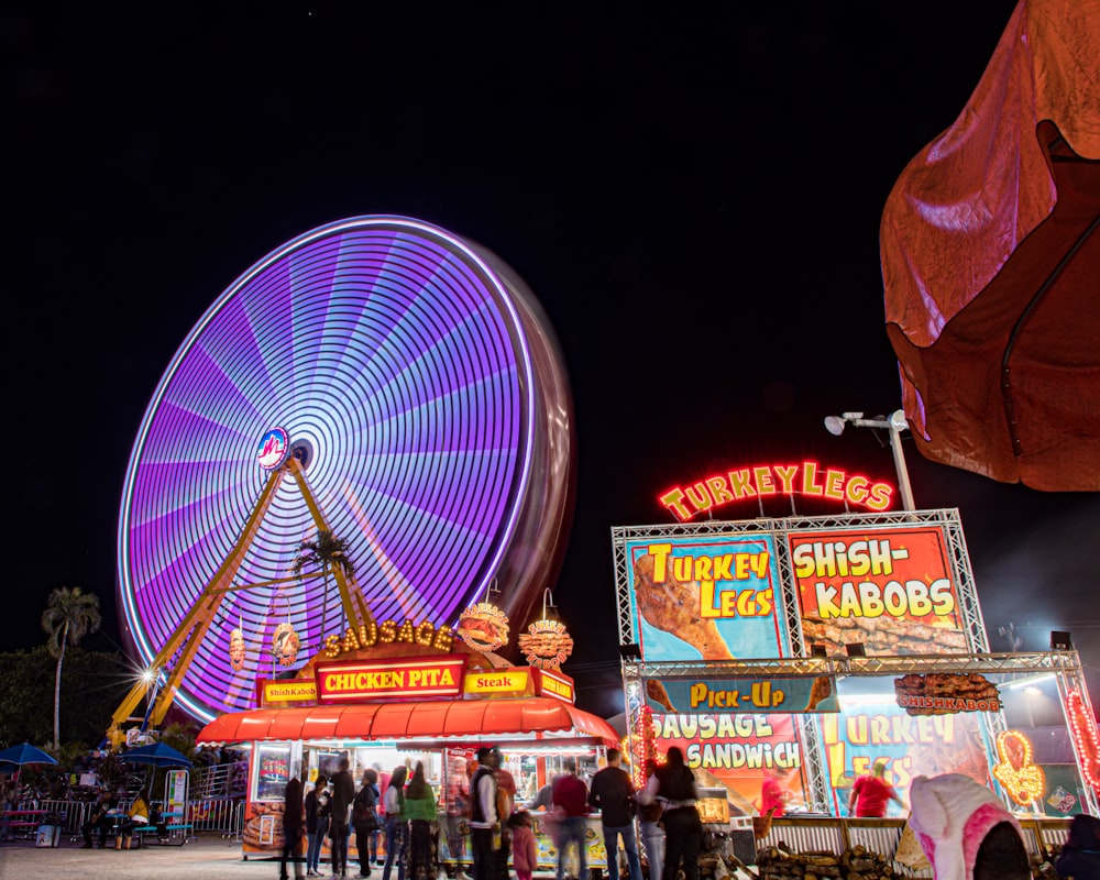 a carnival ride at night with people standing around