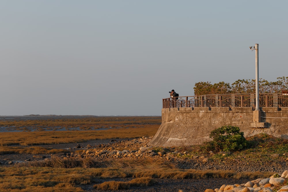 a person riding a bike on a bridge over a body of water