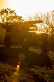 Sunset view over Garut hills with a jeep parked on a ridge, capturing the golden hour glow