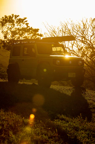 A sleek SUV parked by a mountain trail, bathed in golden hour light.