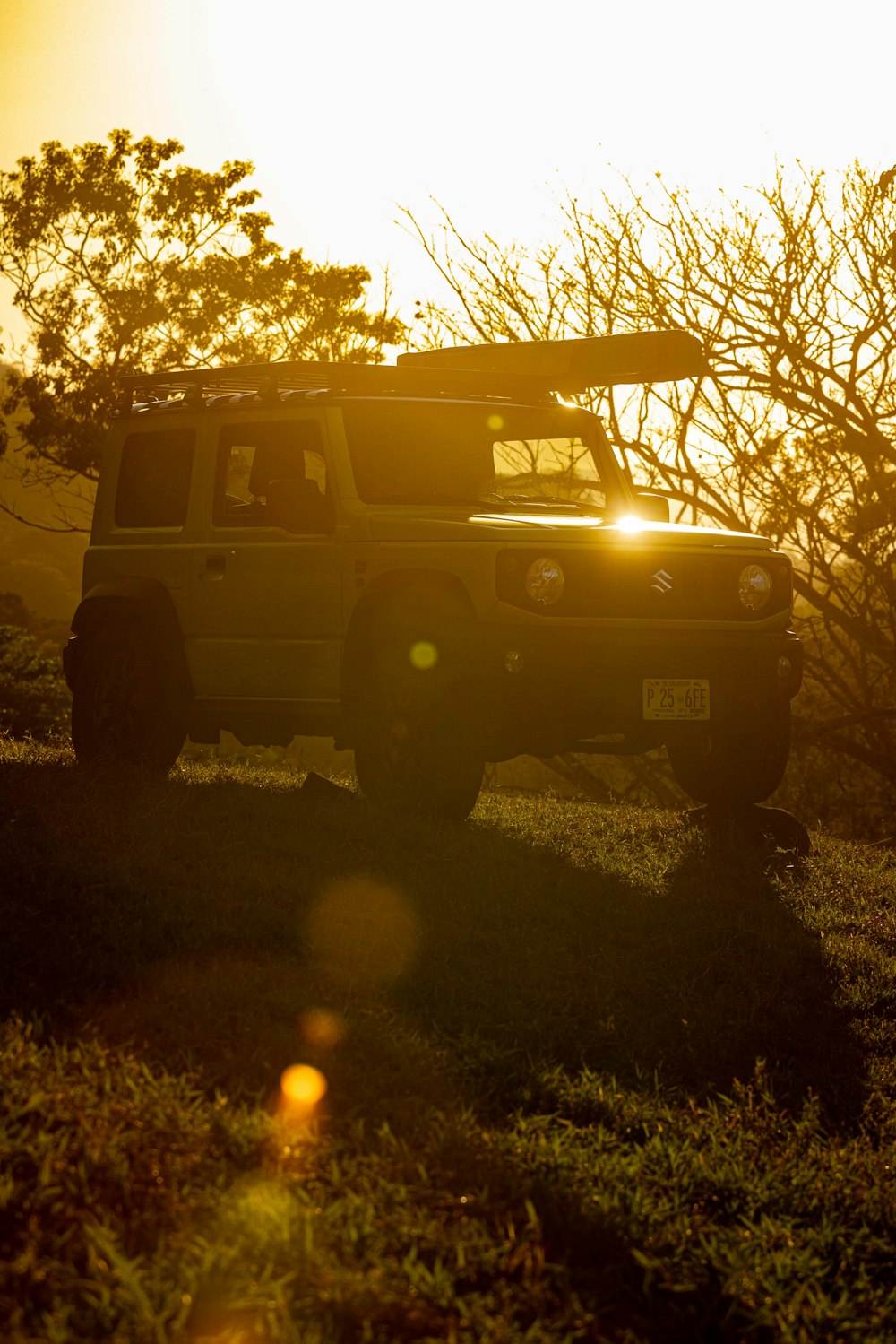 a jeep is parked in a field at sunset