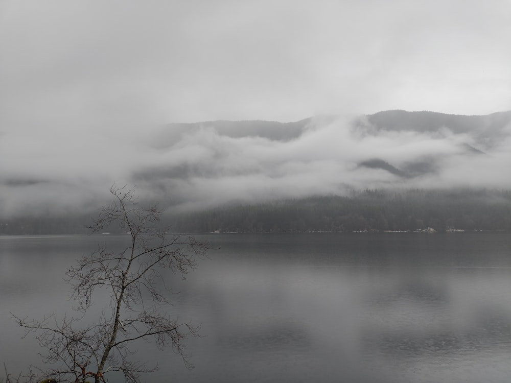 a body of water surrounded by mountains and clouds